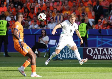Berlin, Almanya - 25 Haziran 2024: Avusturyalı Alexander Prass (R, # 8), Almanya 'nın başkenti Berlin' deki Olympiastadion 'da oynanan UEFA EURO 2024 grup maçında topa vuruyor.