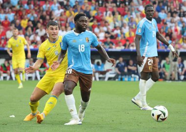 Stuttgart, Almanya - 26 Haziran 2024: Ukraynalı Ruslan Malinovskyi (L, # 8) Belçikalı Orel Mangala (# 18) ile Stuttgart Arena 'da oynanan UEFA 2024 grup maçında top için mücadele ediyor.
