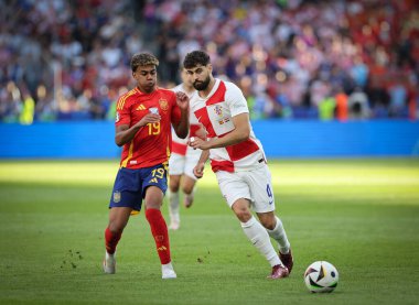 Berlin, Almanya - 15 Haziran 2024: Lamine Yamal (Kızıl), UEFA 2024 grup safhasında Hırvat Josko Gvardiol ile Berlin 'deki Olympiastadion' da oynanan İspanya-Hırvatistan maçında top için mücadele ediyor.