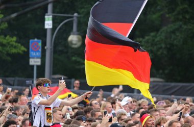 Berlin, Almanya - 5 Temmuz 2024: Alman taraftarlar UEFA 2024 çeyrek final karşılaşması sırasında Berlin 'deki Brandenburg Kapısı' ndaki Fan Bölgesi 'nde desteklerini gösterdiler.