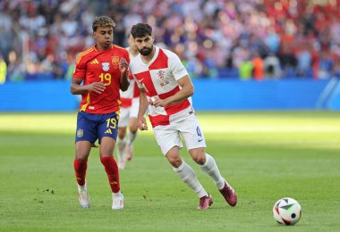 Berlin, Almanya - 15 Haziran 2024: Lamine Yamal (# 19), Berlin 'deki Olympiastadion' da oynanan UEFA EURO 2024 karşılaşmasında Hırvat Josko Gvardiol (# 4) ile top için mücadele ediyor.