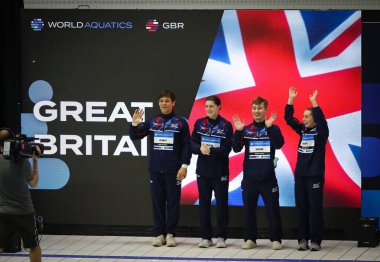 Berlin, Almanya - 22 Mart 2024: Büyük Britanya Takımı 'ndan dalgıçlar, Dünya Sucul Dalgıçları Dünya Kupası 2024 Dünya Kupası' nın Karışık 3 metre & 10 metre Takım Etkinliği Finali sırasında hayranlarını selamlıyorlar.