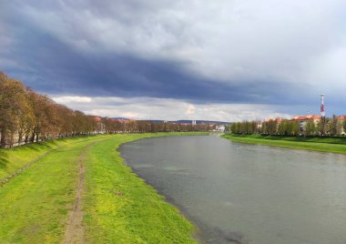 Uzhhorod şehri ve Uzh nehri, Transcarpathia, Ukrayna manzaralı bahar manzarası. Baharın başlarında yemyeşil kıyıları olan sakin bir nehrin manzarası