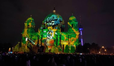 Berlin, Almanya - 6 Ekim 2024: Berlin Katedrali 'nin ön cephesinde (Berliner Dom) her yıl düzenlenen Işık Festivali sırasında bir grup insan aydınlatma gösterisinin tadını çıkarıyor