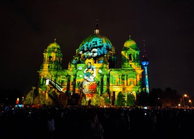 Berlin, Almanya - 6 Ekim 2024: Berlin 'de düzenlenen yıllık Işık Festivali sırasında Berlin Katedrali' nin (Berliner Dom) ön cephesindeki aydınlatma gösterisinin tadını çıkaran bir kalabalık