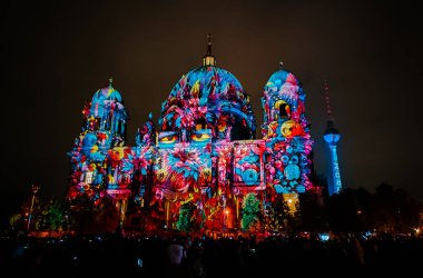 Berlin, Almanya - 6 Ekim 2024: Berlin 'de düzenlenen yıllık Işık Festivali sırasında Berlin Katedrali' nin (Berliner Dom) ön cephesindeki aydınlatma gösterisinin tadını çıkaran bir kalabalık