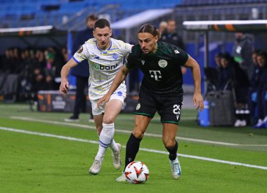 Hamburg, Almanya - 7 Kasım 2024: Dinamo Kyiv 'li Vladyslav Kabaiev (L, 22) Ferencvaros' lu Cebrail Makreckis (# 25) ile Hamburg 'daki UEFA Avrupa Ligi maçı sırasında top için mücadele ediyor.