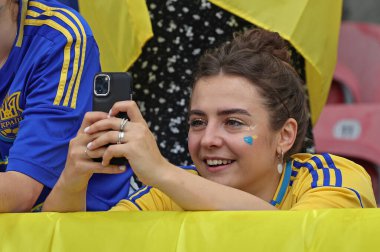 Stuttgart, Almanya - 26 Haziran 2024: Tanımlanamayan Ukraynalı destekçi, Almanya 'nın Stuttgart kentindeki Stuttgart Arena' da oynanan UEFA 2024 grup oyunu sırasında akıllı telefonuyla fotoğraf çekiyor
