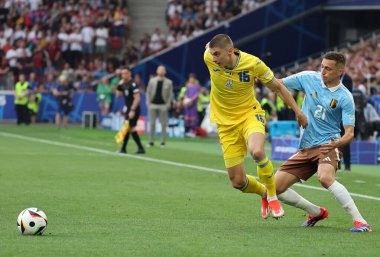 Stuttgart, Almanya - 26 Haziran 2024: Vitaliy Mykolenko (# 16), Stuttgart 'taki Stuttgart Arena' da oynanan UEFA 2024 grup maçında Belçikalı Timothy Castagne (# 21) ile top için mücadele ediyor.