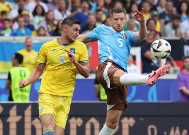 Stuttgart, Almanya - 26 Haziran 2024: Ukraynalı Roman Yaremchuk (# 9) Belçikalı Jan Vertonghen (# 5) ile Stuttgart 'taki Stuttgart Arena' da oynanan UEFA EURO 2024 grup maçında top için mücadele ediyor.