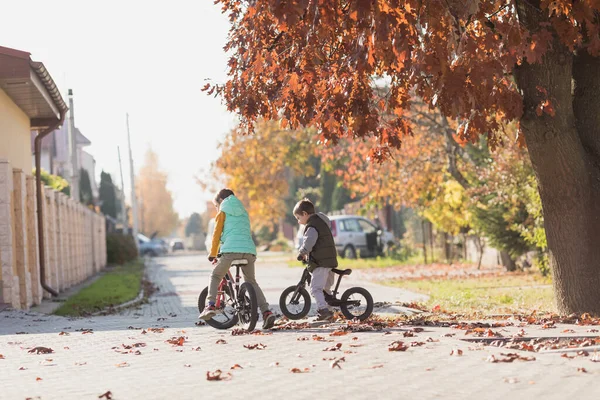 在阳光灿烂的秋日 孩子们骑自行车和自行车 — 图库照片