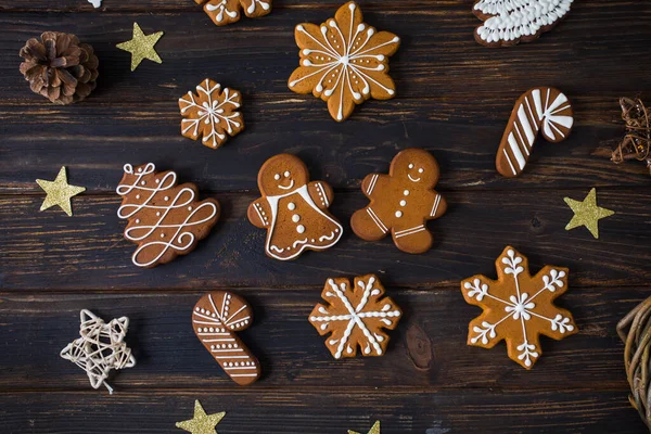 木製のテーブルの上に砂糖の装飾釉薬と様々な形状のクリスマスクッキー 装飾とフラットレイアウト — ストック写真