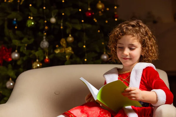 Mooi Klein Meisje Zit Stoel Naast Een Mooi Versierde Kerstboom — Stockfoto