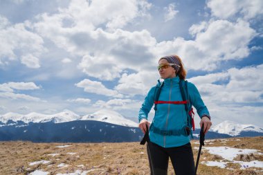 Yürüyüş yapan kadın, bahar başında Carpathian dağlarında safran çiçeklerini sever.