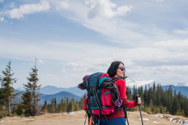 Sırt çantalı ve İskandinav bastonlu kadın yürüyüşçüler Karpat dağlarında, arka manzara