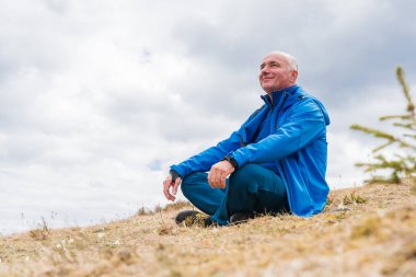 Erkek yürüyüşçü, bahar başında Karpat dağlarında çiçek açan kar damlalarından hoşlanır.