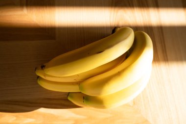 Mutfağın ahşap zemininde bir sürü muz yatıyor.