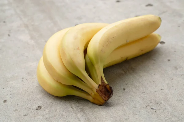 成熟的香蕉捆在混凝土的背景上 顶视图 图库照片