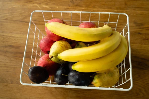 有新鲜水果的篮子放在厨房的桌子上 香蕉放在前边 图库图片