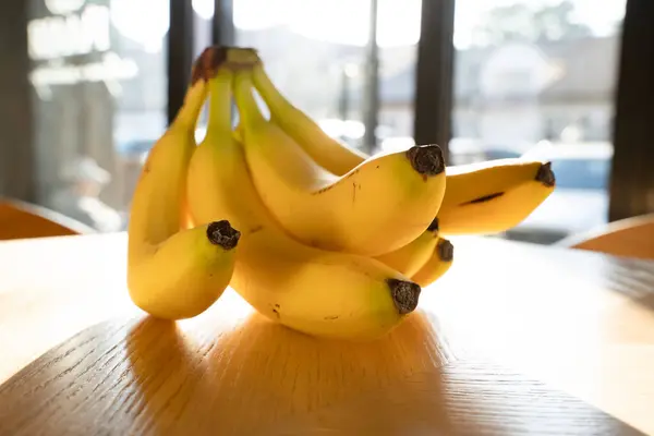 キッチンで木の背景に横たわるバナナの打ち合わせ ロイヤリティフリーのストック写真