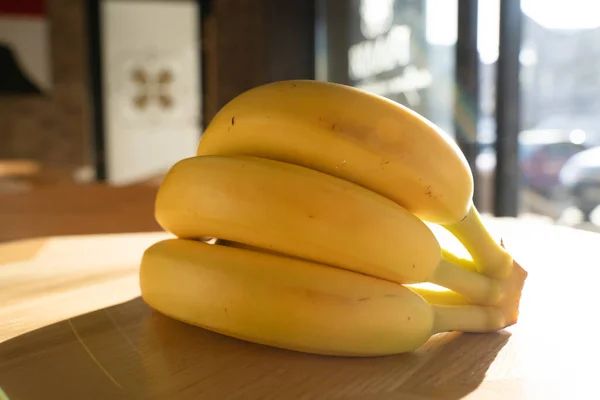 一堆香蕉躺在厨房的木制底座上 免版税图库图片