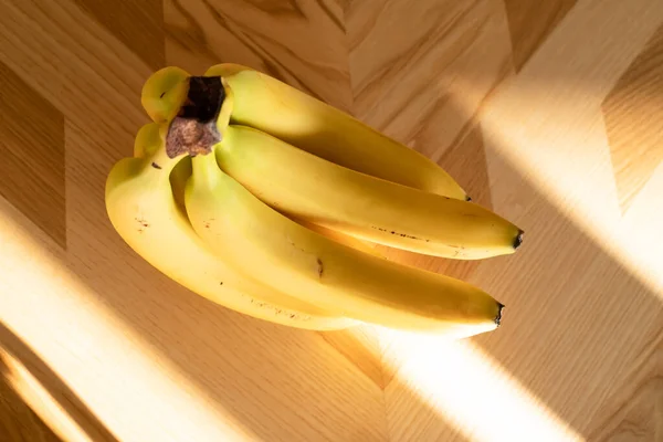 成熟的香蕉束在木制的背景上 顶部的视图 免版税图库图片