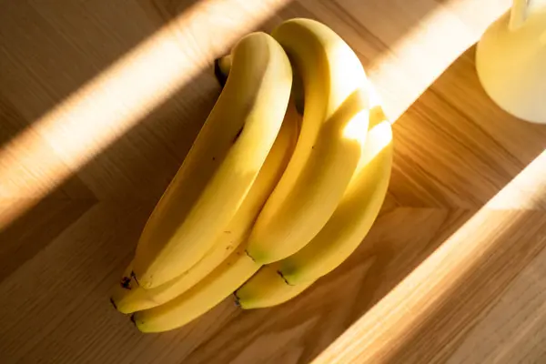 成熟的香蕉束在木制的背景上 顶部的视图 图库图片