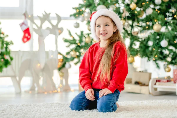 Niña Pequeña Con Sombrero Santa Navidad Sentada Sonriendo Casa Decorada —  Fotos de Stock