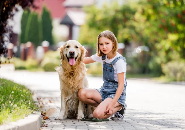 路上でゴールデンレトリバー犬をペットとして飼っている少女 女子供子供の子供とともに純血犬ラブラドール座っています地上 — ストック写真