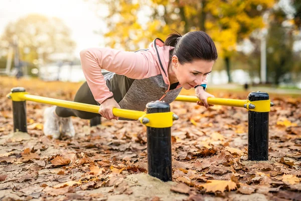 フィットネスの女の子は秋の時間に屋外でプッシュアップを行う 公園で運動する若い女性 — ストック写真
