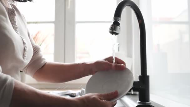厨房里用水槽洗透明玻璃杯的人 家庭主妇在室内洗碗 — 图库视频影像