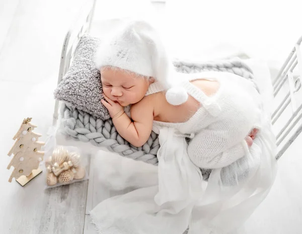 Neugeborener Junge Mit Strickhose Und Mütze Schlafend Auf Winzigem Bett — Stockfoto
