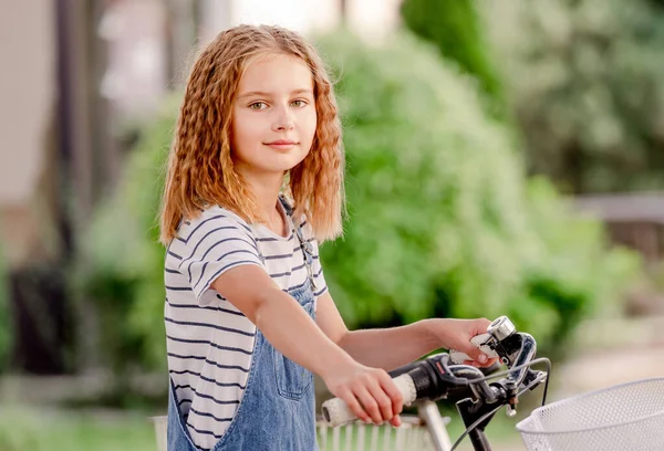 可爱的小女孩坐在自行车停放上的脚踏摩托车上 — 图库照片