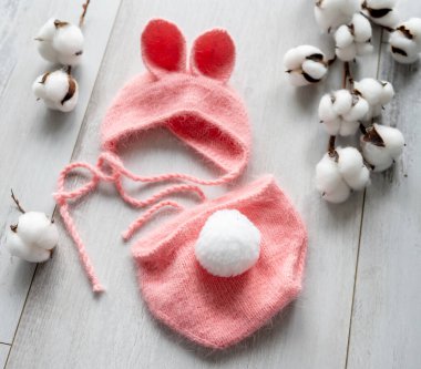 Yeni doğmuş bebek kıyafetleri ahşap bir masanın üzerine örülmüş.