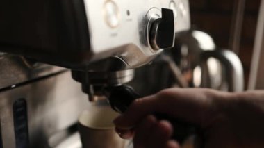 Girl hand turn on coffee maker for fresh aromatic cappuccino at home. Aroma espresso preparation process with modern latte machine