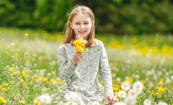 Little Girl Holding Yellow Blowballs Flowers Hands Sitting Blossom Field — Foto Stock