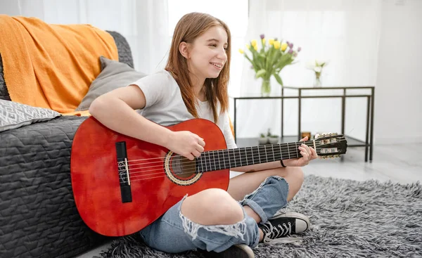 自宅でギターを練習している少女ティーンエイジャーが床に座っている ギタリスト楽器付き — ストック写真