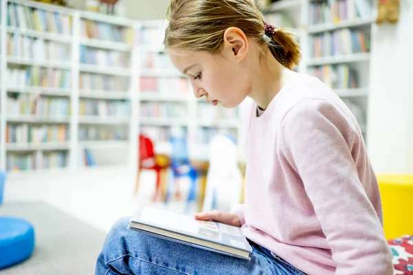 女学生在学校图书馆选书 聪明的女孩选择阅读的文献 书店架子上的书 从书本中学习 学校教育 日常阅读的益处 — 图库照片