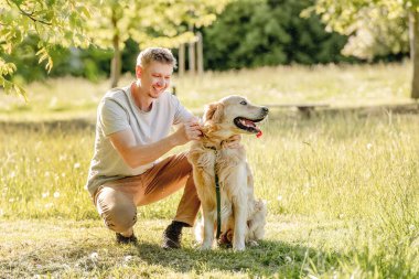 Doğada tasmalı Golden Retriever 'da yürüyen adam