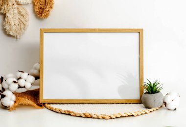 Wooden frame for photos and candle in scandinavian interior mockup. Minimal template with empty picture at home