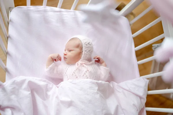Újszülött Kislány Kötött Sapkát Visel Gyerekágyban Fekszik Felülről Nézve Csecsemő — Stock Fotó