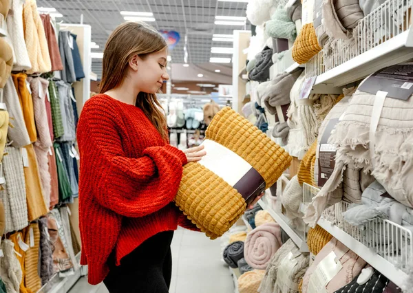 漂亮的女孩在超市里选择床毯做家居装饰 漂亮的少女在购物中心里买平民装房间 — 图库照片