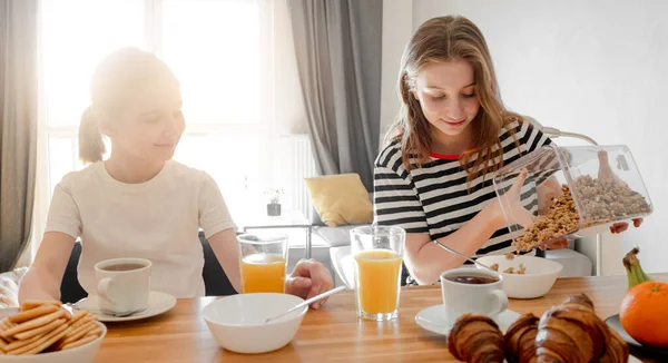 女の子の姉妹一緒においしい朝食を食べ オートシリアル食事でプレートを埋めます 女性の子供と朝の栄養の間にムスリ食品とすすり泣き — ストック写真