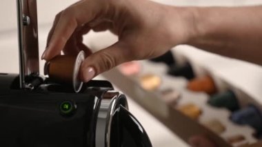 Kahve makinesinin yakın çekimine kız eli kahve kapsülü koydu. Profesyonel makinede Espresso cappuccino içeceği hazırlama