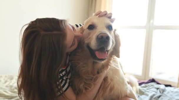 Красива Дівчина Обіймає Золотого Собаку Ретривера Посміхається Сидячи Ліжку Жіночий — стокове відео
