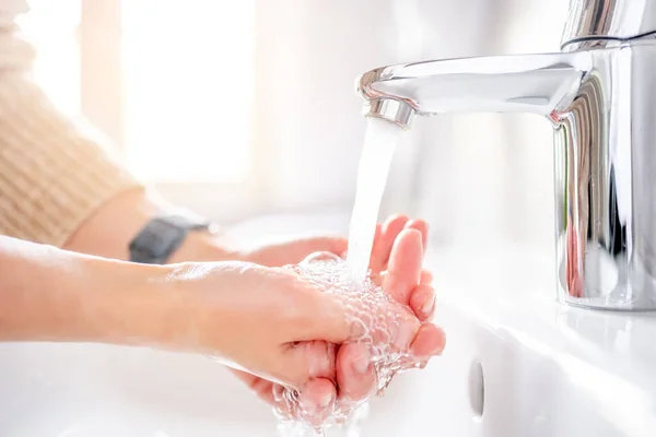 若いです女性洗浄彼女の手で石鹸でシンク上にバスルーム クローズアップ — ストック写真