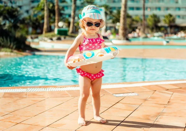 可爱的小女孩在游泳池游泳圈附近 — 图库照片