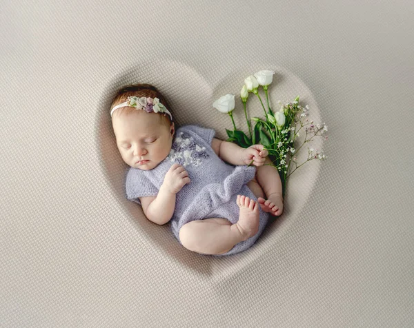新生児の女の子身に着けていますニットドレスと花輪睡眠でハート形とともにホワイトバラスタジオポートレート — ストック写真