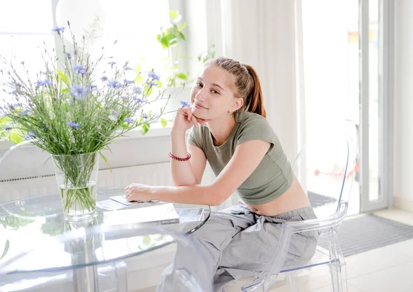 Gyönyörű Lány Asztalnál Virágokkal Ablak Mellett Mosolyog Csinos Tinédzser Lány — Stock Fotó