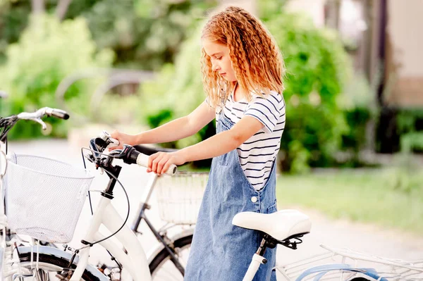 可爱的小女孩坐在自行车停放上的脚踏摩托车上 — 图库照片